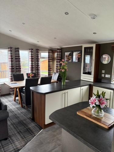 a kitchen with a counter with flowers on it at Hepburns Lodge 19 in Strachan