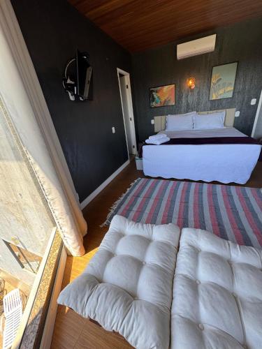 a bedroom with a white bed and a couch at Pousada Recanto Querubins in Paty do Alferes