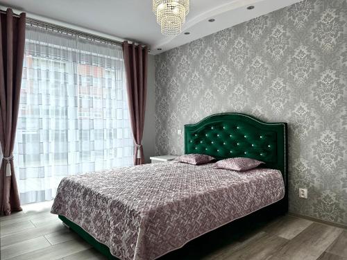 a bedroom with a bed with a green headboard and a window at Czartoryskiego Apart - Self Check-In 20h - Parking &Lift & 50m Terrace in Wrocław