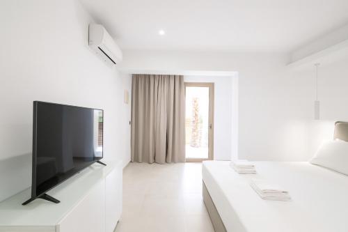 a white living room with a flat screen tv at Mono Alex Afitos in Afitos