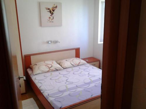 a small bedroom with a bed with pink sheets at Villa Sol in Vinišće