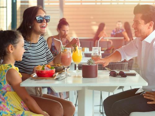 a group of people sitting at a table eating food at Novotel Arica in Arica