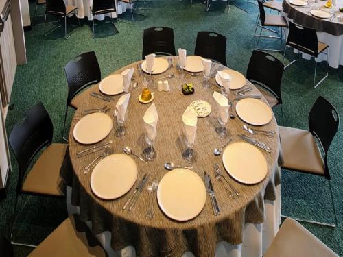 a large wooden table with plates and wine glasses at Novotel Arica in Arica