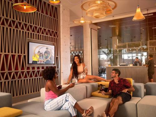 a group of people sitting on couches in a room at Novotel Arica in Arica