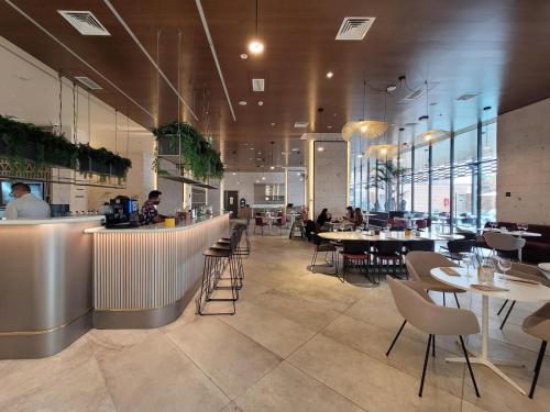 a restaurant with tables and chairs and a bar at Novotel Arica in Arica