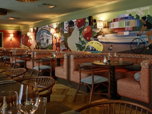 a restaurant with tables and chairs and a bar at 25hours Hotel Indre By in Copenhagen