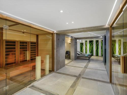 an open hallway with glass doors and a living room at Mercure Tokaj Center in Tokaj