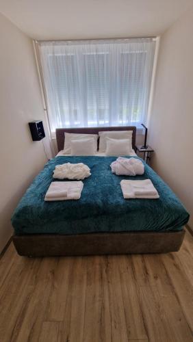 a bedroom with a large bed with towels on it at Queen Emma's Place in Debrecen