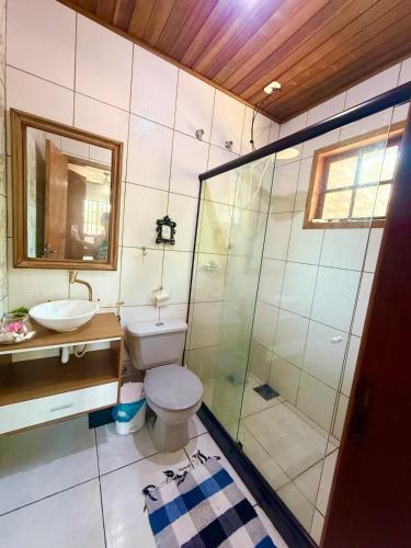 a bathroom with a toilet and a sink and a shower at Meu Refúgio Praia Seca in Araruama