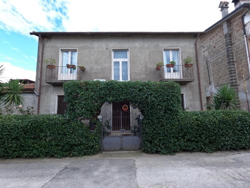 an ivy covered house with a gate in front of it at Dimora Sardo in Pietramelara