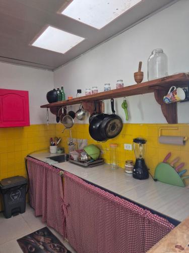 a kitchen with yellow tiles and a counter top at Casa rustica y familiar con piscina en La Vega Cund in La Vega