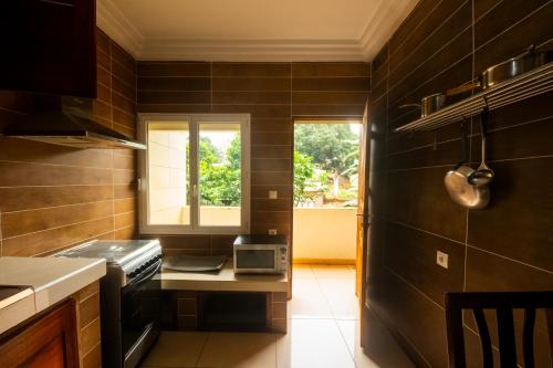 a kitchen with a stove and a window at Residence MASSOU in Yaoundé