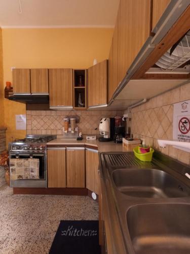 a kitchen with wooden cabinets and a stainless steel sink at Dimora Sardo in Pietramelara