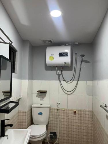 a bathroom with a shower and a toilet and a sink at Cozy Coron Inn in San Nicolas