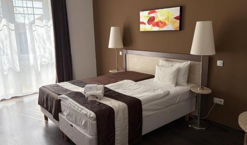 a hotel room with a bed with a suitcase on it at Hotel Opal Superior - Adults Only in Gyöngyös