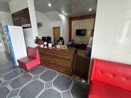a waiting room with a counter and a red chair at Hotel Hưng phát 3 có Sạc Vinfast in Kinh Thượng