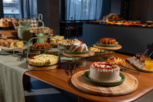 Laghetto Stilo Garden في غرامادو: طاولة مليئة بمختلف أنواع الكعك والمعجنات