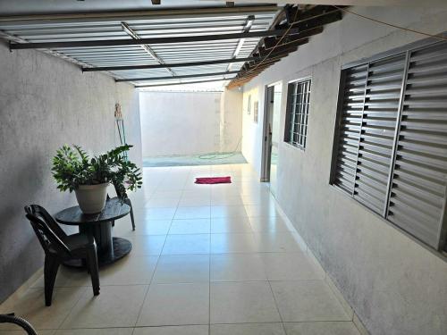 a hallway with a table and a potted plant at Casa Umuarama - Espaçosa e Confortável in Umuarama