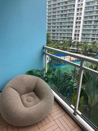 a white bean bag chair sitting on a balcony at Zelle Luxxe - Azure Staycation Resort in Manila