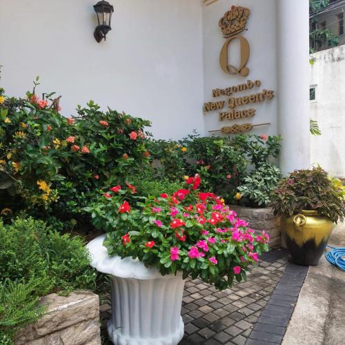 two vases filled with flowers in front of a building at Negombo New Queen's Palace in Negombo