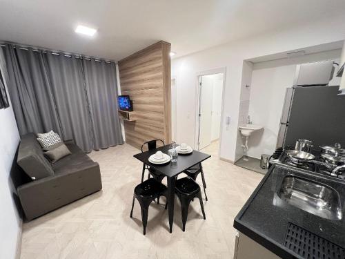 a living room with a small table and a kitchen at LK Centro 10 in Belo Horizonte