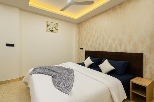 a bedroom with a large bed with blue pillows at Home Escape Azure 3BHK Bunglow Near Apollo DB City in Indore