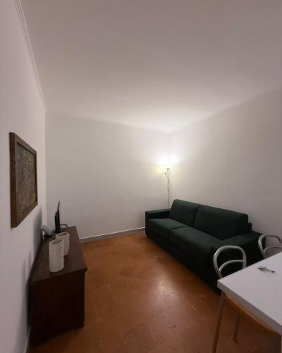 a living room with a green couch and a table at La petite Crema in Crema