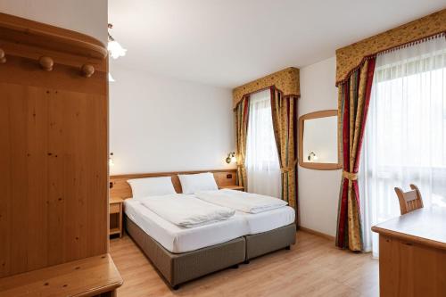 Una cama o camas en una habitación de Hotel Genzianella