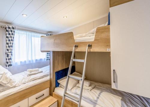 a small bedroom with bunk beds and a ladder at Hanworth Country Park in Potter Hanworth