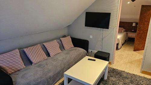 a living room with a couch and a table at Hôtel La Poterne du Roy in Rocroi