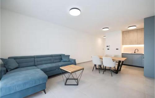 a living room with a blue couch and a table at 2 Bedroom Lovely Apartment In Privlaka in Glavan
