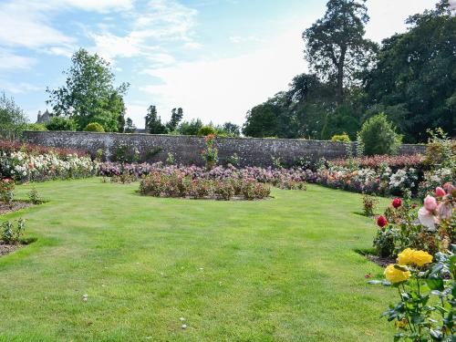 a garden with colorful flowers and a stone wall at The Garden Rooms in Montrose