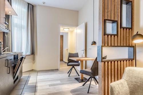 a kitchen and a living room with a table and chairs at Hotel Esplanade Dortmund in Dortmund