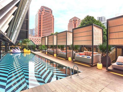a large pool with couches and chairs on a building at Pullman Singapore Orchard in Singapore