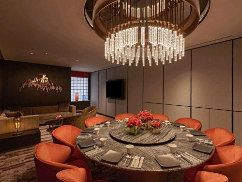 a dining room with a table and chandeliers at Pullman Singapore Orchard in Singapore