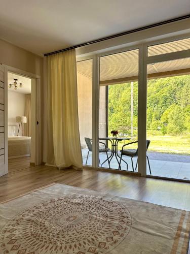a living room with a large glass door and a table at KalyNove апартаменти in Verkhniy Yasenov