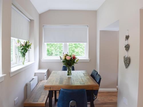 a dining room table with a vase of flowers on it at Forth View-Uk34217 in Aberfoyle