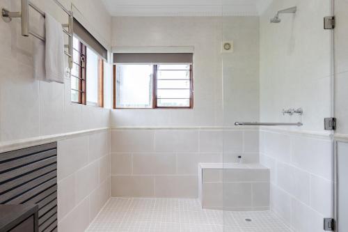 a white bathroom with a tub and a sink at Matumi Golf Lodge in Nelspruit