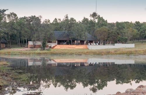 una casa en la orilla de un cuerpo de agua en Ilanga Lodge, en Vaalwater