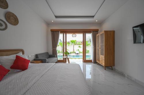 a bedroom with a bed and a living room at De Luxora Villa Canggu in Kerobokan