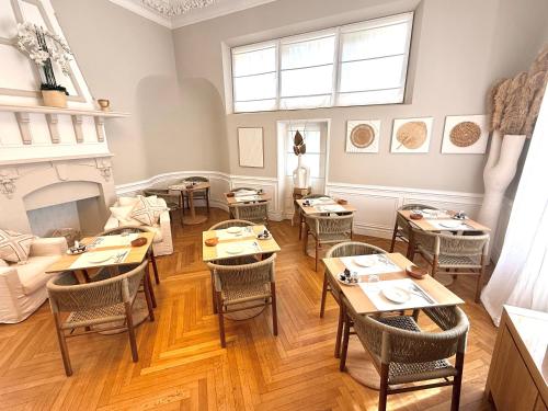 a dining room with tables and chairs and a fireplace at Villa Claudia Hotel Cannes Centre - Parking in Cannes