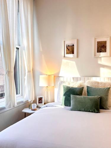 a bedroom with a white bed with green pillows at Cozy 1BR Apt Downtown Steps from Convention Center in Providence