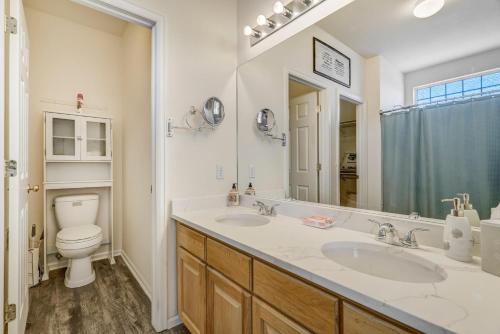 a bathroom with two sinks and a toilet at The Cozy Oak - Main Level Comforts in Fountain