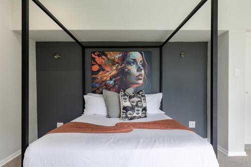 a bedroom with a large bed with a painting on the wall at Matumi Golf Lodge in Nelspruit