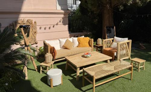 a patio with a couch and chairs and a table at Villa Claudia Hotel Cannes Centre - Parking in Cannes