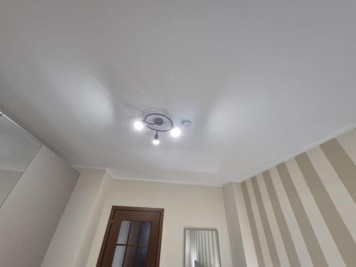 a white ceiling with a ceiling fan and a door at Fantastic Apartmet Carignano-BORGO MERCATO MONCALIERI in Moncalieri
