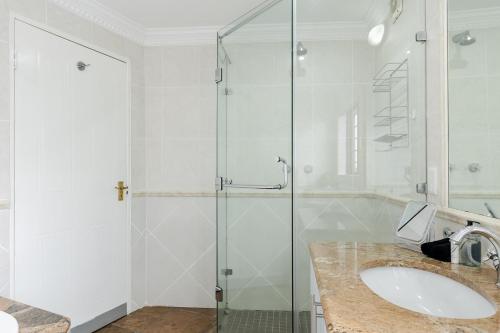 a bathroom with a sink and a glass shower at Matumi Golf Lodge in Nelspruit