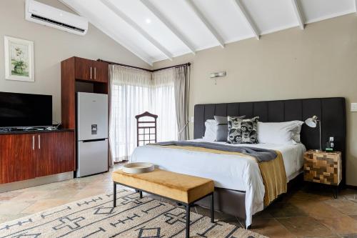 a bedroom with a large bed and a tv at Matumi Golf Lodge in Nelspruit