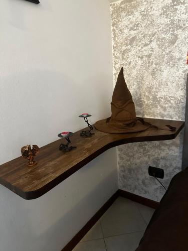 a wooden table with a hat and two stools on it at La casa magica in Cuggiono
