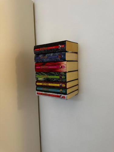a stack of books sitting on top of a refrigerator at La casa magica in Cuggiono